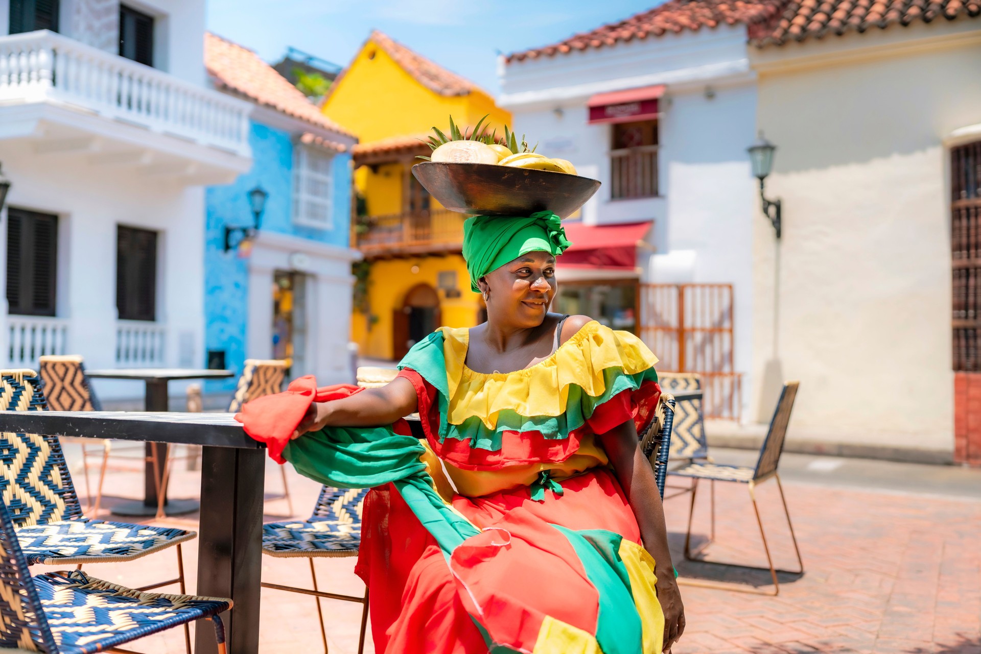 Palenquera woman in traditional dress relaxing in Cartagena street café Palenquera woman in traditional dress relaxing in Cartagena street café